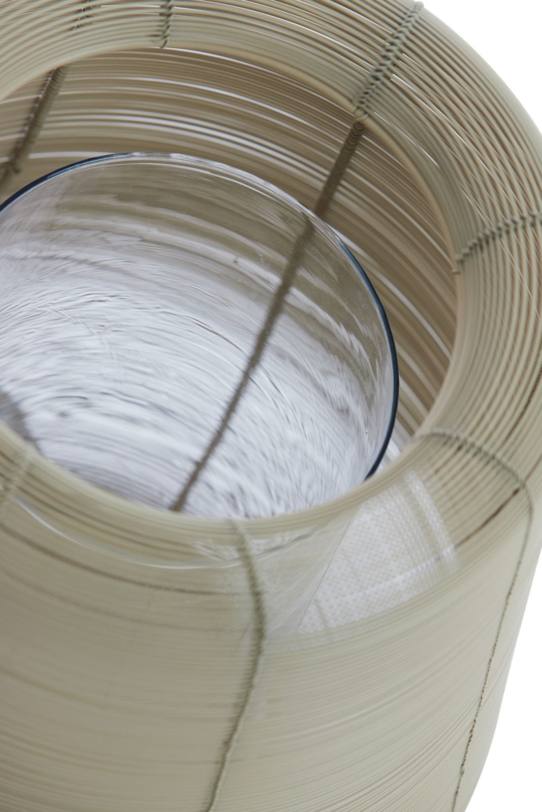 Nahaufnahme eines Windlichts aus geflochtenem Material mit Glaszylinder, von oben betrachtet.