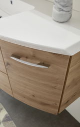 Nahaufnahme einer Badkombination mit Holzoptik und weißem Waschbecken, seitliche Perspektive