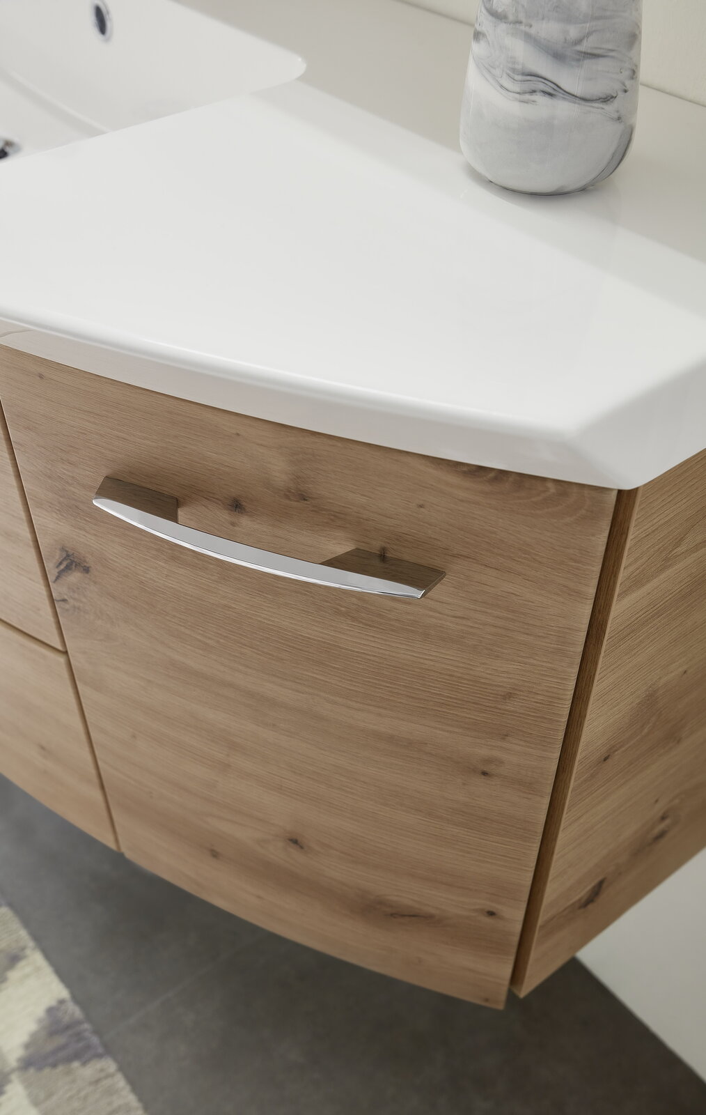 Nahaufnahme einer Badkombination mit Holzoptik und weißem Waschbecken, seitliche Perspektive