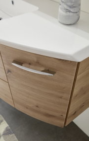 Nahaufnahme einer Badkombination mit Holzoptik und weißem Waschbecken, seitliche Perspektive