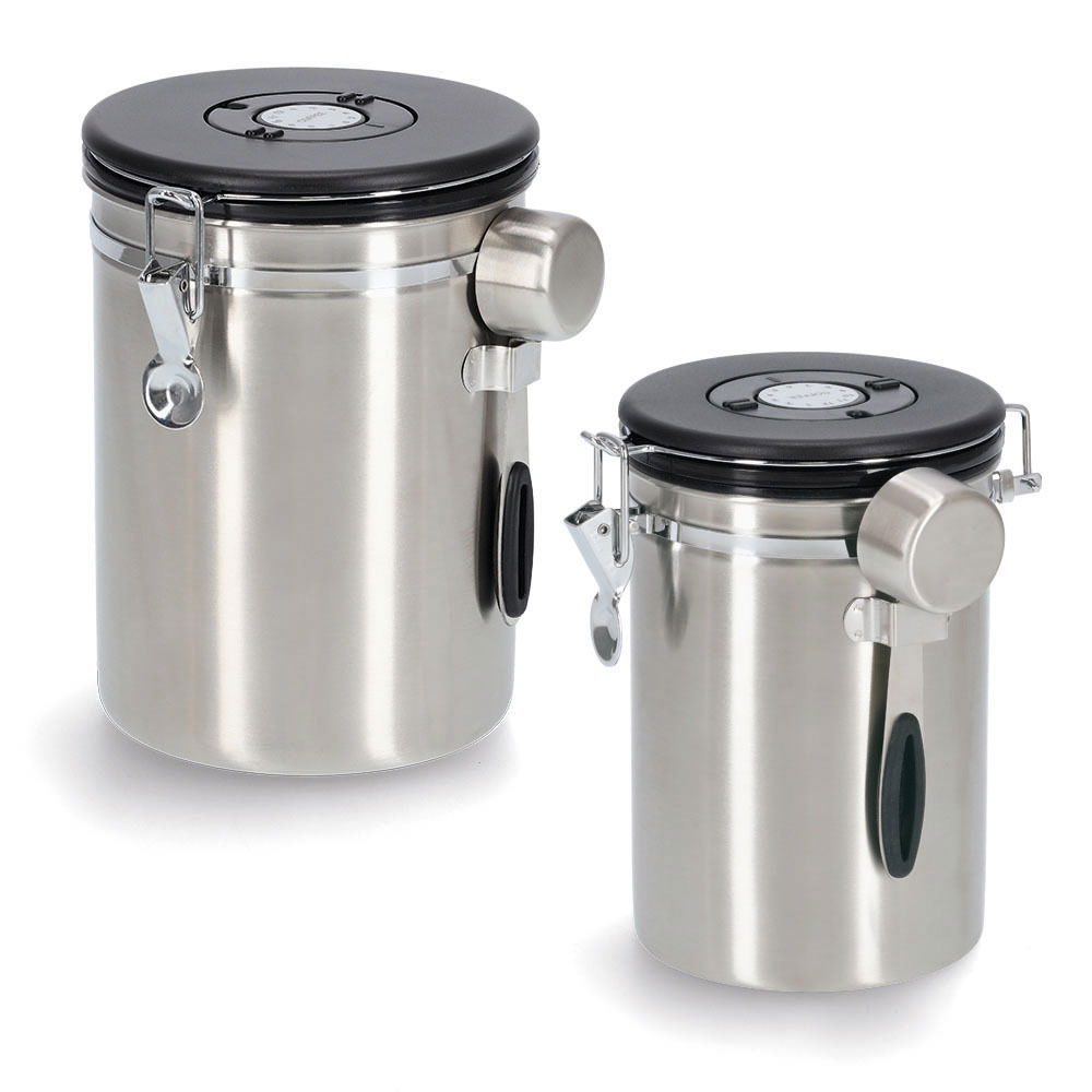 Zwei silberne Kaffeedosen mit schwarzem Deckel und Löffel, aus seitlicher Perspektive fotografiert.