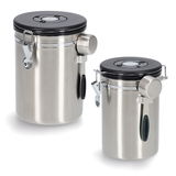 Zwei silberne Kaffeedosen mit schwarzem Deckel und Löffel, aus seitlicher Perspektive fotografiert.