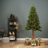Künstlicher Weihnachtsbaum Tiaga Tanne, 180 cm hoch, in einem modernen Wohnzimmer mit Geschenken und Dekorationen, seitliche Perspektive.