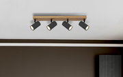 Deckenstrahler mit vier schwarzen, zylinderförmigen Leuchten an einer Holzleiste, Perspektive von unten