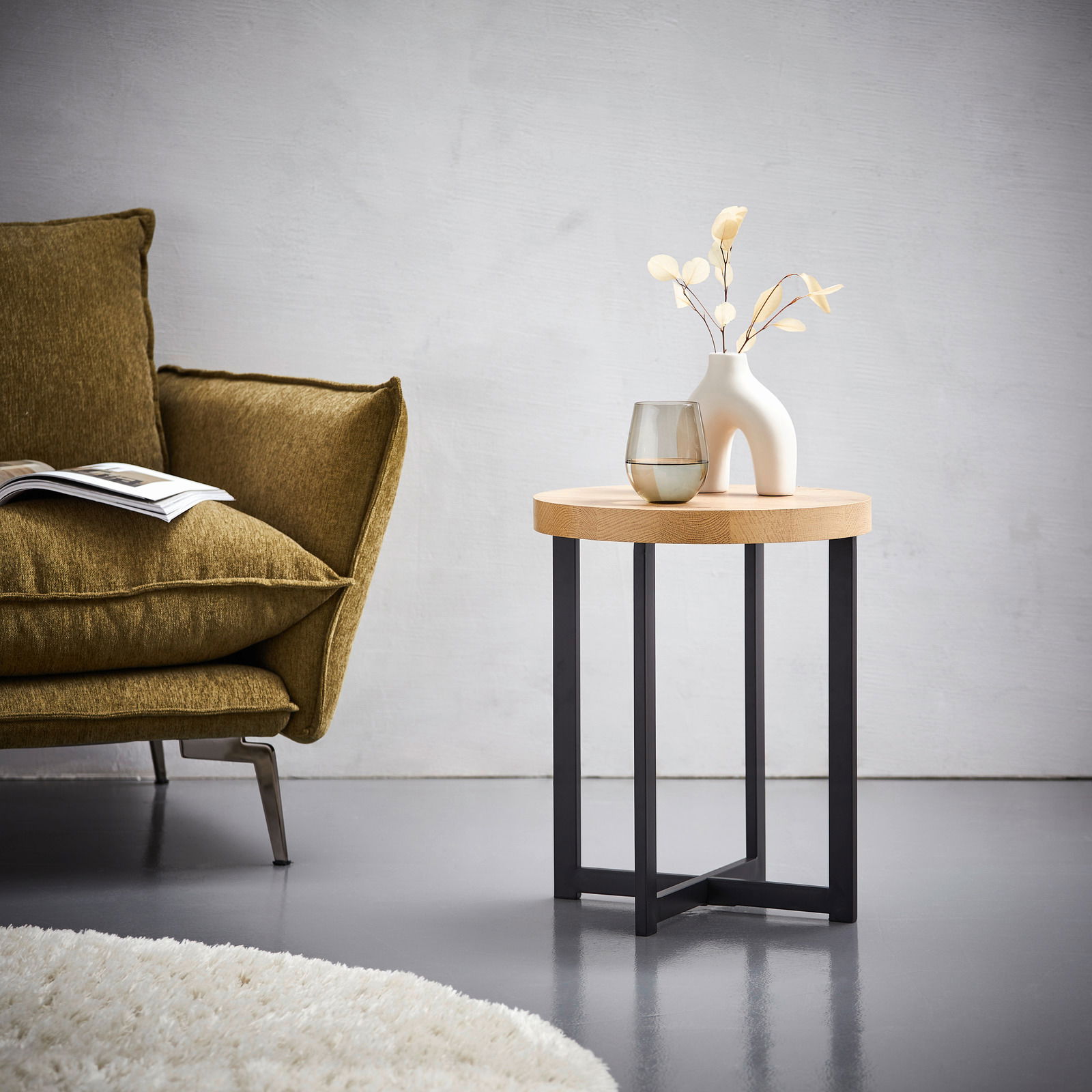 Moderner Beistelltisch mit runder Holzplatte und schwarzen Metallbeinen, seitliche Perspektive