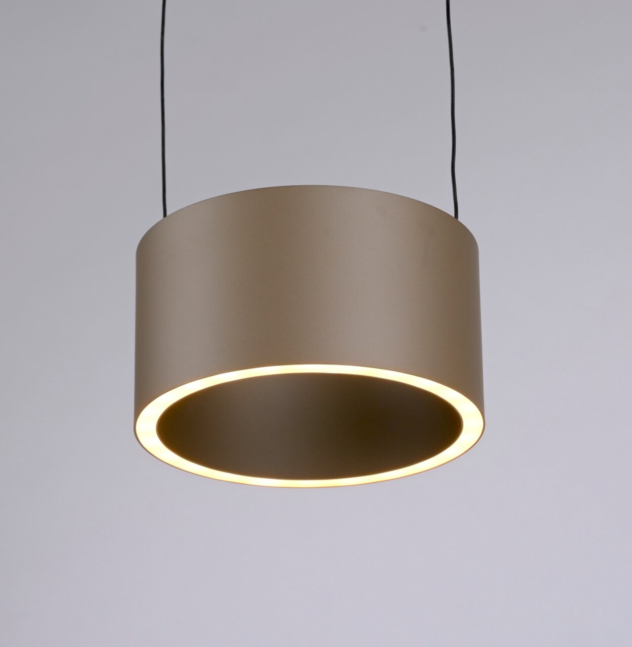 Moderne LED-Pendelleuchte in zylindrischer Form, von unten betrachtet, mit warmem Lichtschein.