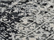 Nahaufnahme eines Designer-Teppichs mit einem schwarz-weißen, abstrakten Muster. Die Perspektive zeigt eine diagonale Ansicht der Textur.