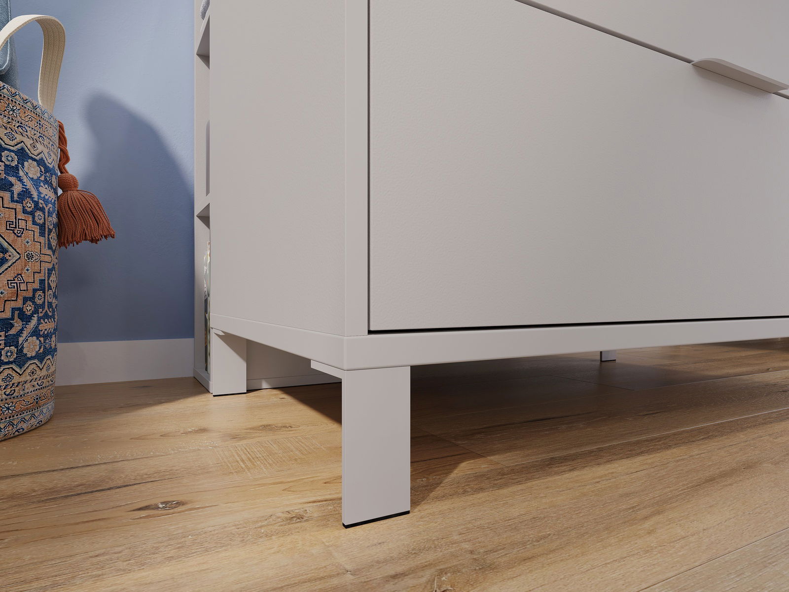 Nahaufnahme einer weißen Kommode auf Holzfußboden, seitliche Perspektive