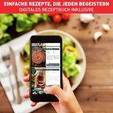 Person hält ein Smartphone mit digitalen Rezepten in der Hand, im Hintergrund ein Teller mit frischem Salat. Perspektive von oben auf den Tisch.