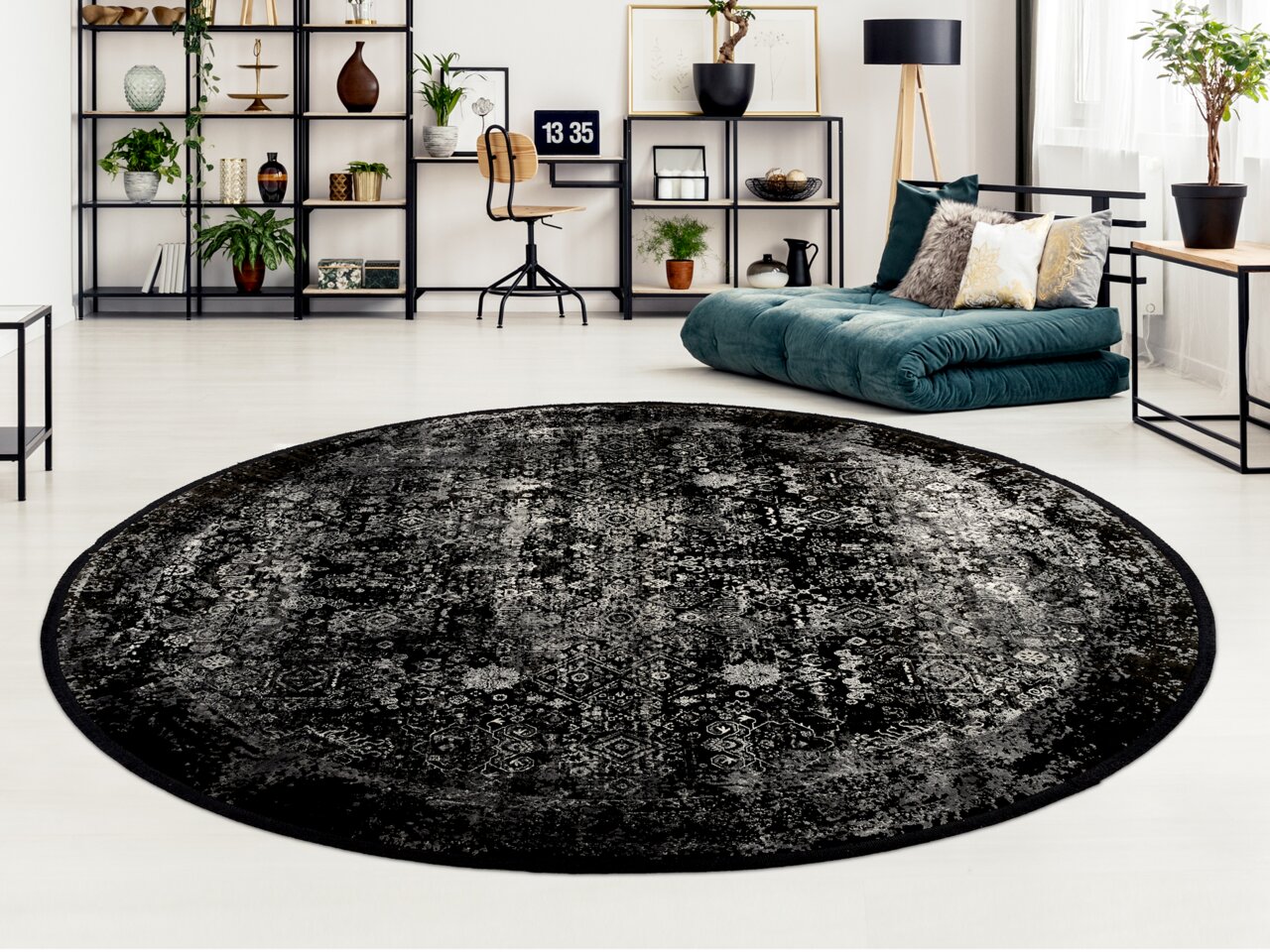 Runder Designer Teppich in Schwarz mit grauen Mustern in einem modernen Wohnzimmer, Perspektive von oben.