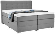 Graues Boxspringbett mit hohem Kopfteil, seitliche Perspektive