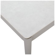 Nahaufnahme eines modernen Loungetisches mit heller Tischplatte und abgerundeten Ecken, Perspektive von oben.