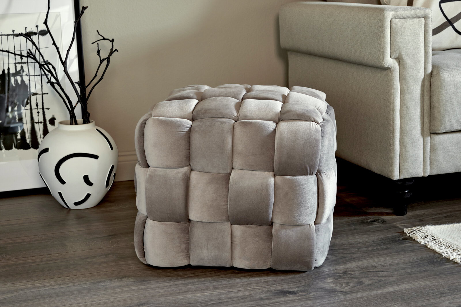 Jahnke Hocker WEB ART Grauer, gepolsterter Hocker in Würfelform mit quadratischem Muster, seitliche Perspektive.