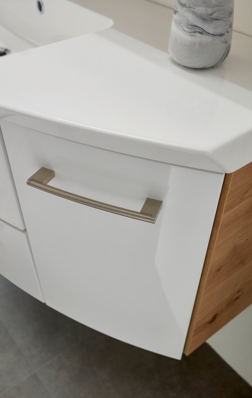 Nahaufnahme einer modernen Badkombination mit weißer Front und Holzseite, Blick von oben.