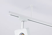 Weiße Decken-Stromschiene mit abgehängter Leuchtenhalterung und Spot, Detailansicht aus Untersicht in leichter Schrägperspektive