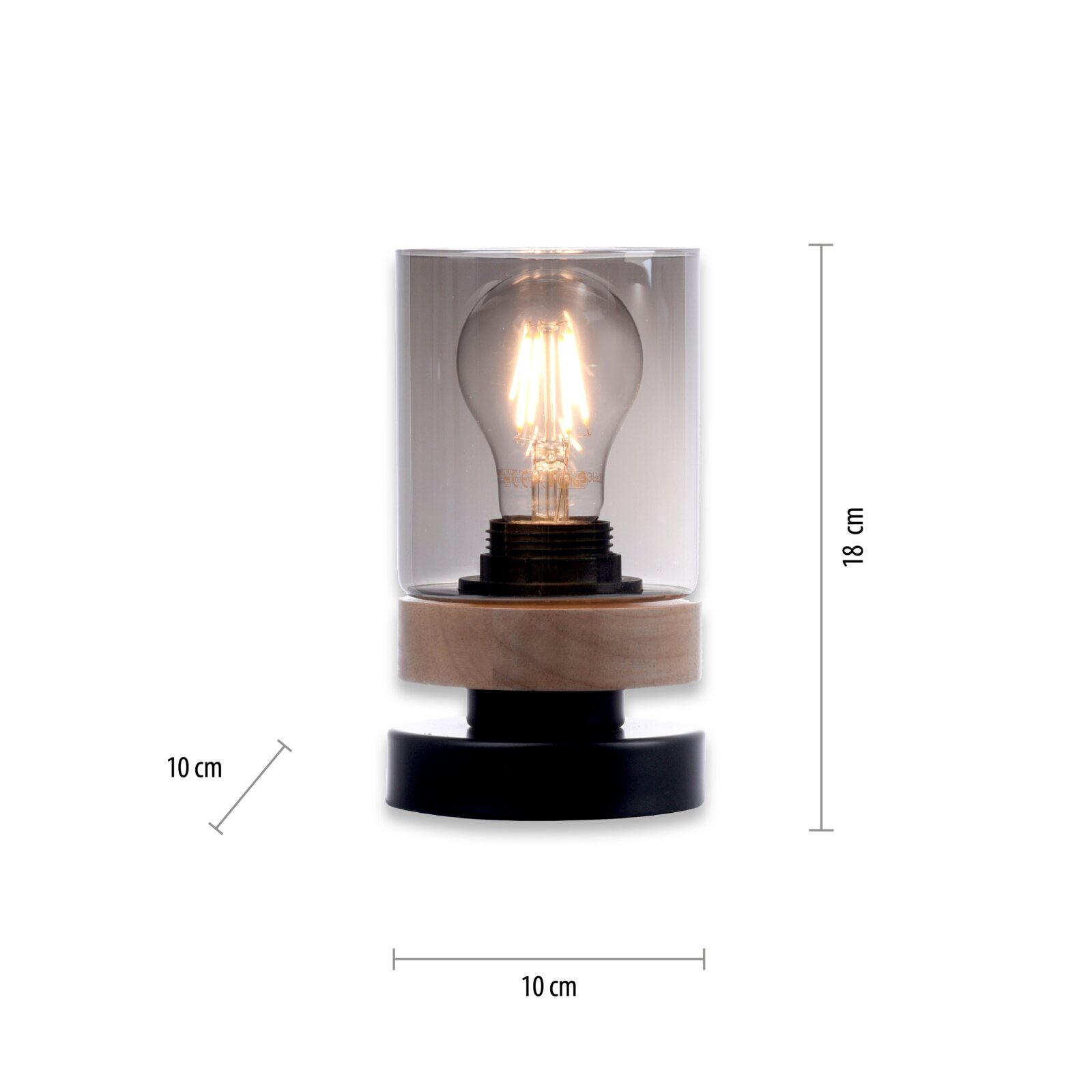 Moderne Tischleuchte mit transparentem Glaszylinder, sichtbarer Filament-Glühbirne und Holzsockel auf schwarzem Fuß, ca. 18 cm hoch und 10 cm Durchmesser, frontal aus der Vorderansicht fotografiert