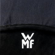 Detailfoto van bovenaf van een zwarte, zachte stof met een wit geborduurd WMF-logo op een donkere achtergrond