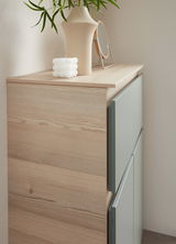 Nahaufnahme eines Unterschranks mit Abdeckplatte aus Holz, dekoriert mit einer Vase, einem Spiegel und einer Kerze, seitliche Perspektive.