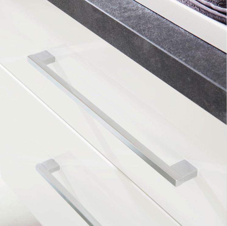 Nahaufnahme einer Badkombination mit weißen Schubladen und modernen, silbernen Griffen aus der Vogelperspektive.