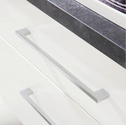 Nahaufnahme einer Badkombination mit weißen Schubladen und modernen, silbernen Griffen aus der Vogelperspektive.