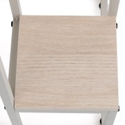 Hellbraune Holz-Sitzfläche eines weißen Stuhls, Ansicht von oben (Draufsicht)
