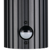 Nahaufnahme einer schwarzen Außenwandleuchte mit geriffelter Oberfläche und integriertem Bewegungssensor.