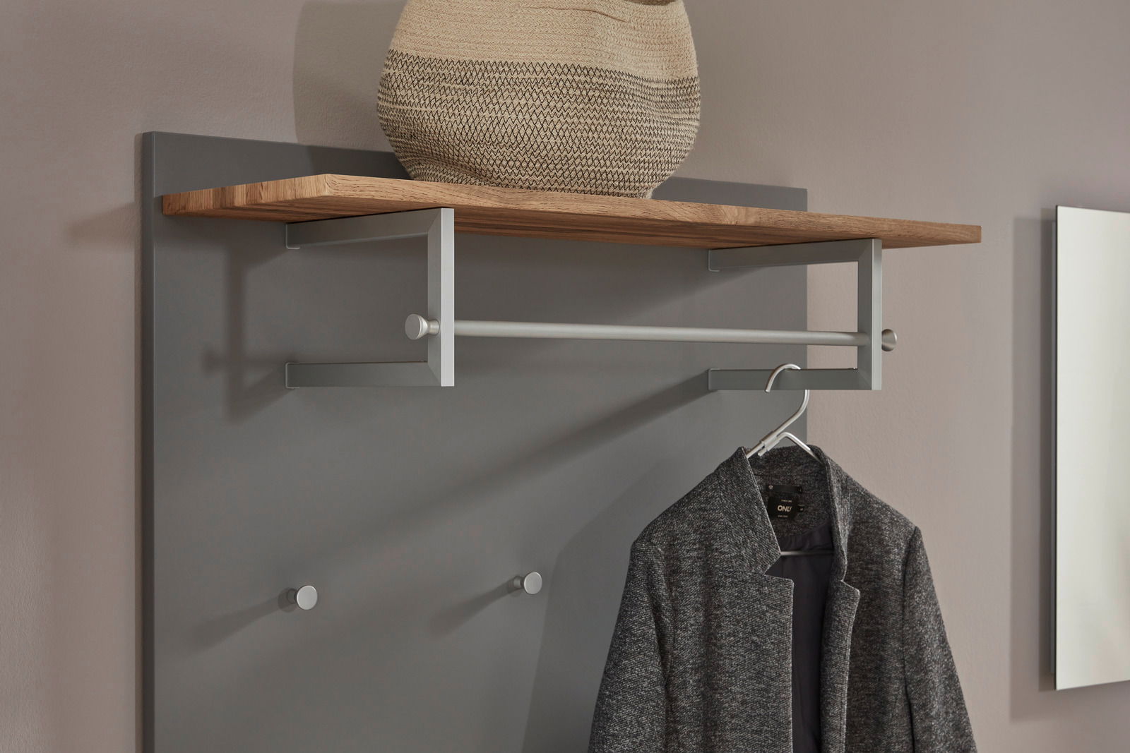 Garderobenpaneel in Nahaufnahme, mit Holzablage, Kleiderstange und Haken, von vorne betrachtet.