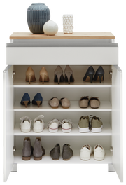 Schuhschrank mit mehreren Regalböden, gefüllt mit verschiedenen Schuhen, aus der Frontalperspektive. Obenauf stehen dekorative Vasen.