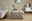 Hocker mit gepolstertem, geflochtenem Design in einem modernen Wohnzimmer, seitliche Perspektive