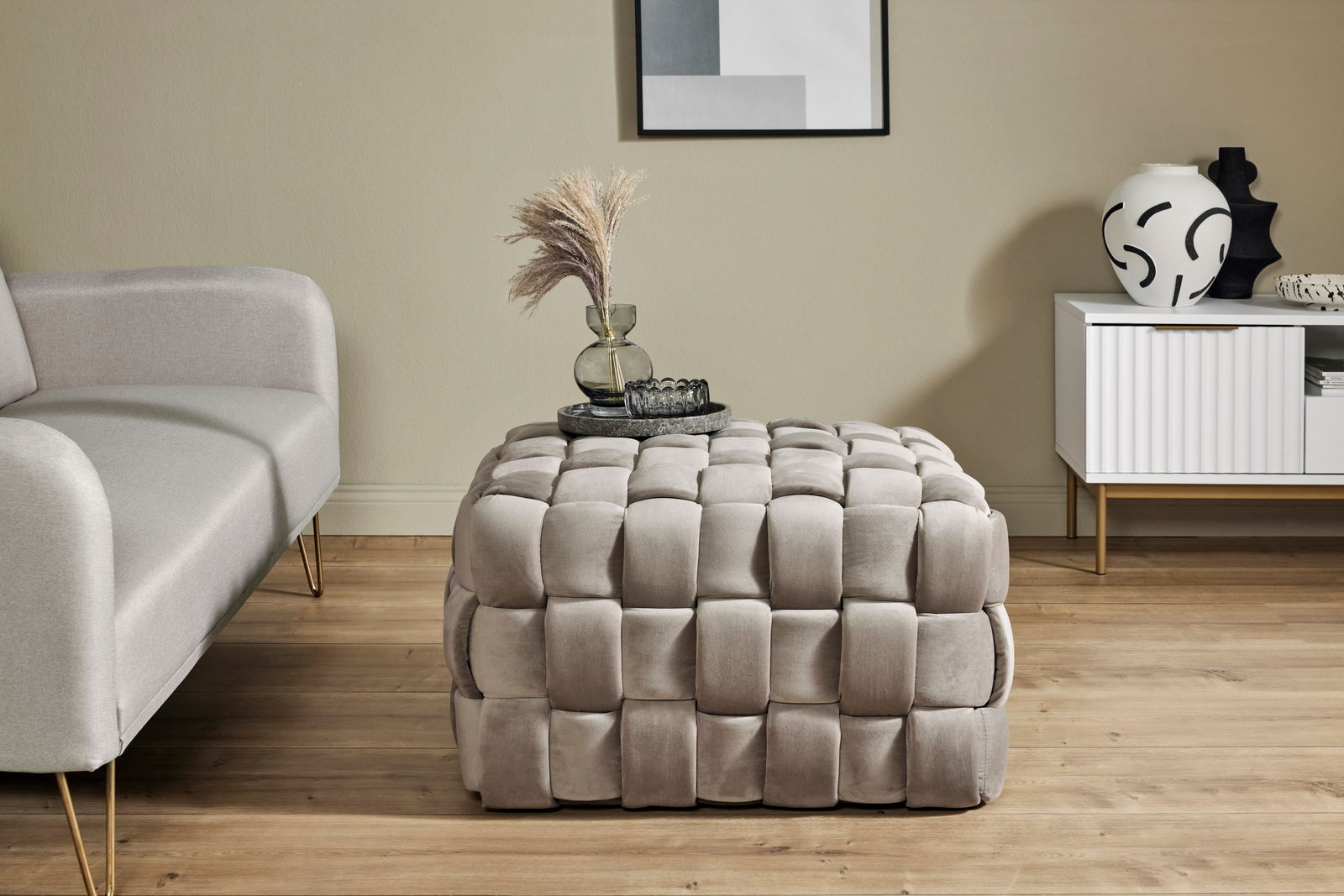 Hocker mit gepolstertem, geflochtenem Design in einem modernen Wohnzimmer, seitliche Perspektive