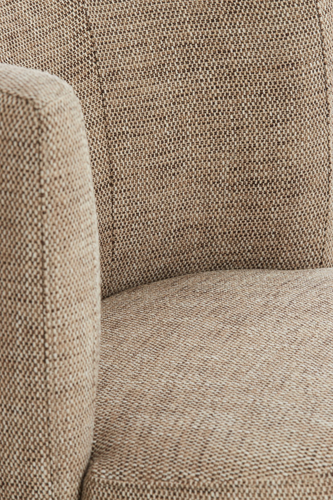 Nahaufnahme eines Sessels mit beige-braunem Stoffbezug, seitliche Perspektive.