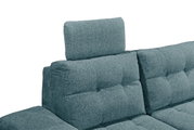 Nahaufnahme einer modernen, gepolsterten Sofaecke in Blaugrün mit verstellbarer Kopfstütze, seitliche Perspektive.