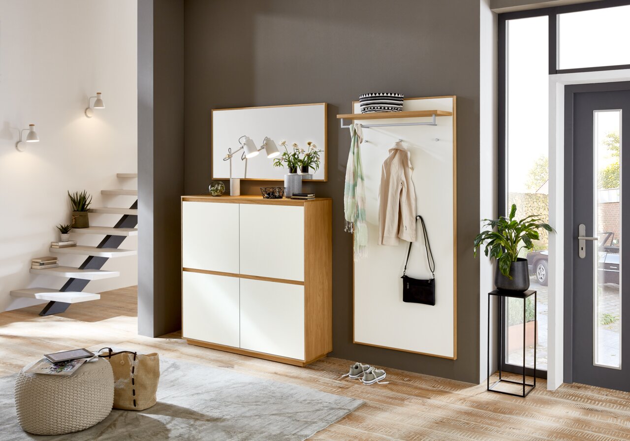 VOSS XL-garderobepaneel, lang V100 Moderne garderobe-inrichting met schoenenkast, spiegel en garderobepaneel in een lichte gang, gezien vanaf de zijkant.