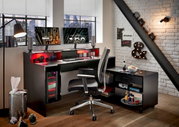 Moderner Gaming-Schreibtisch mit zwei Monitoren, beleuchtetem PC-Gehäuse und ergonomischem Stuhl, seitliche Perspektive.