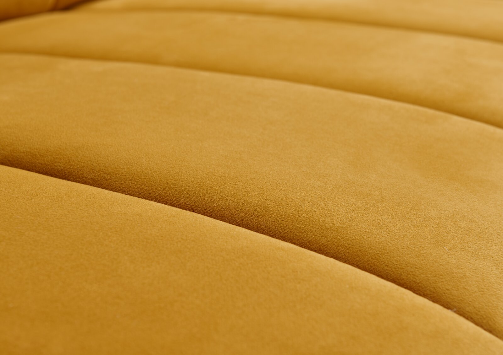 Nahaufnahme einer gelben Polsterrundecke aus weichem Stoff, seitliche Perspektive