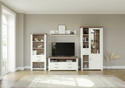 Wohnzimmeransicht mit moderner Vitrine, TV-Schrank und Regal in Holzoptik, frontal betrachtet.