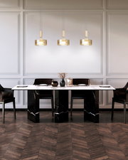 Modernes Esszimmer mit weißer Tischplatte auf schwarzen Marmorblöcken, vier schwarzen Stühlen und drei hängenden Glas-Pendelleuchten, frontale Perspektive auf den Tisch