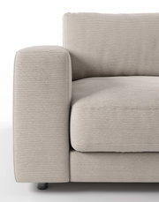 Close-up van een beige tweezitsbank met geribbelde stoffen bekleding, gezien vanaf de linkerkant.