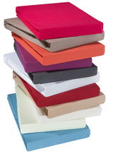 Stapel von Jersey-Spannbetttüchern in verschiedenen Farben, von oben betrachtet.