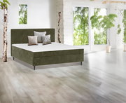 Boxbett in einem modernen, hellen Raum mit großen Fenstern und grüner Aussicht, seitliche Perspektive