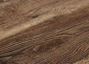 Nahaufnahme einer Holzoberfläche mit natürlicher Maserung, perspektivisch von der Seite aufgenommen.