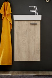 Modernes Bad-Waschbecken mit weißem Aufsatzbecken auf hellem Holz-Unterschrank, verchromtem Einhebelmischer und gelbem Handtuch an dunkler Wand, Frontalansicht.