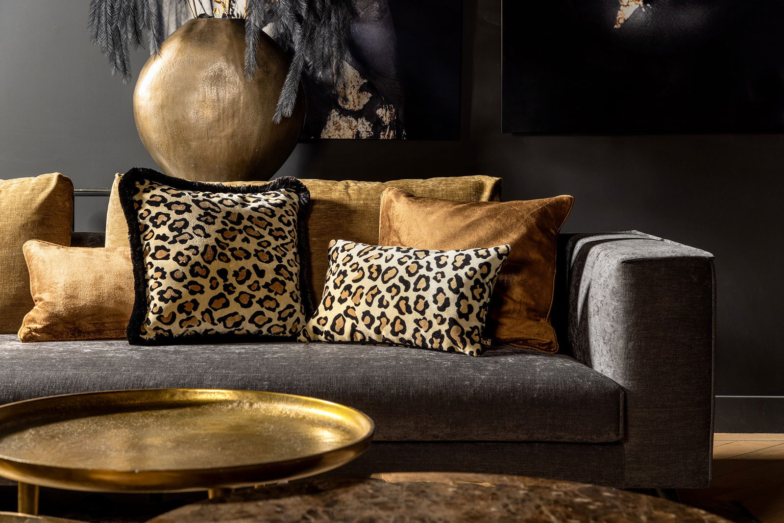hoii Dekokissen EVITA Leopardenmuster-Dekokissen auf einem grauen Sofa, umgeben von goldenen Kissen, mit einem goldenen Tisch im Vordergrund. Perspektive: Frontalansicht.