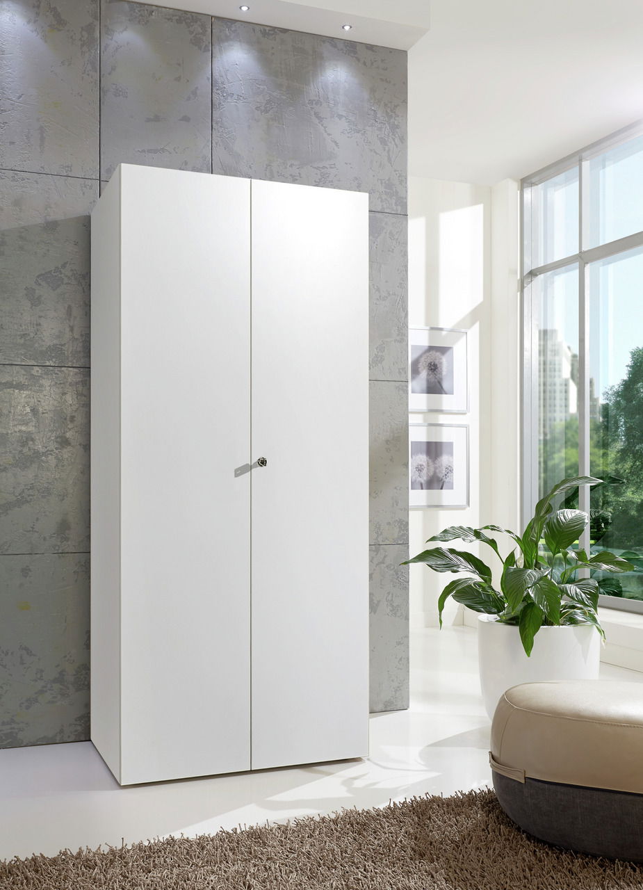 XORA Mehrzweckschrank mit Schloss MULTIRAUMKONZEPT Weißer Mehrzweckschrank mit Schloss, frontal abgebildet in einem modernen, hellen Raum mit großen Fenstern und Pflanzen.