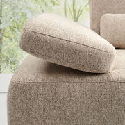 Nahaufnahme eines beigen Longchairs mit strukturierter Oberfläche, seitliche Perspektive.