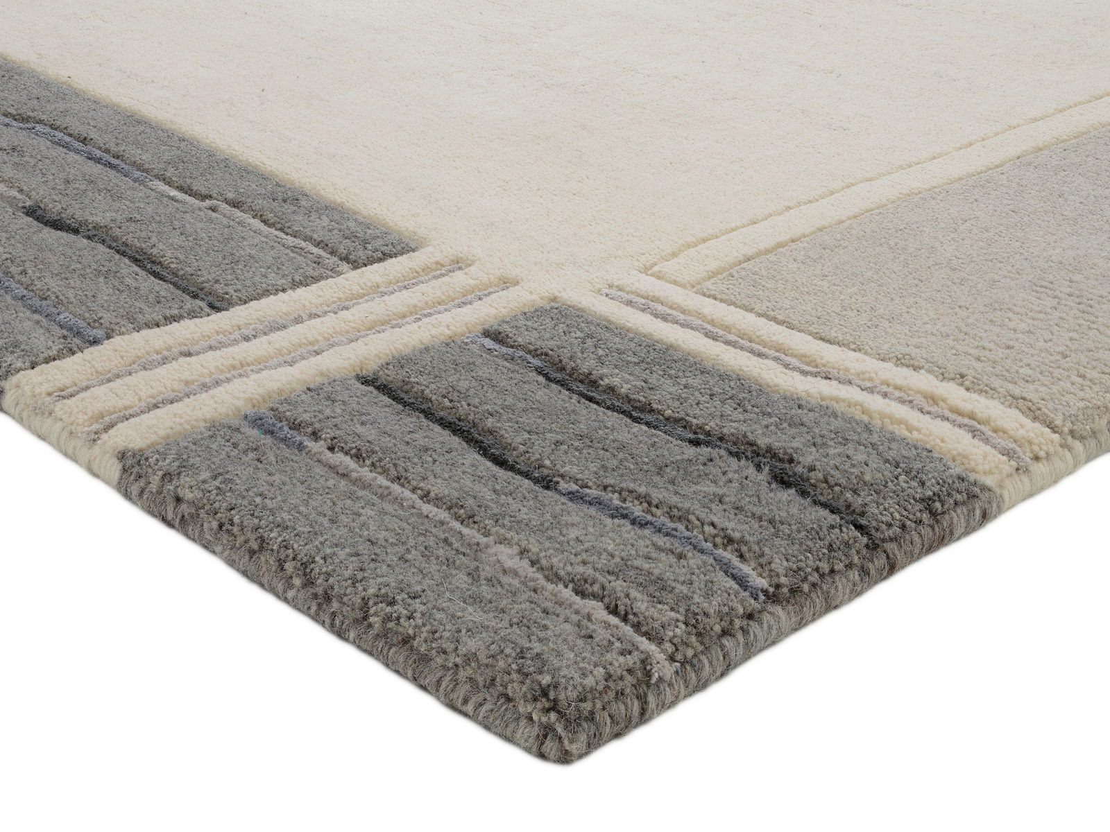 Ecke eines Wollteppichs mit grauen und cremefarbenen Streifen, seitliche Perspektive