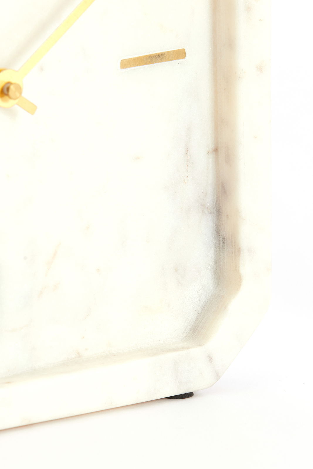 Nahaufnahme einer eleganten Uhr mit einem Zifferblatt aus weißem Marmor und goldenen Zeigern, seitliche Perspektive.