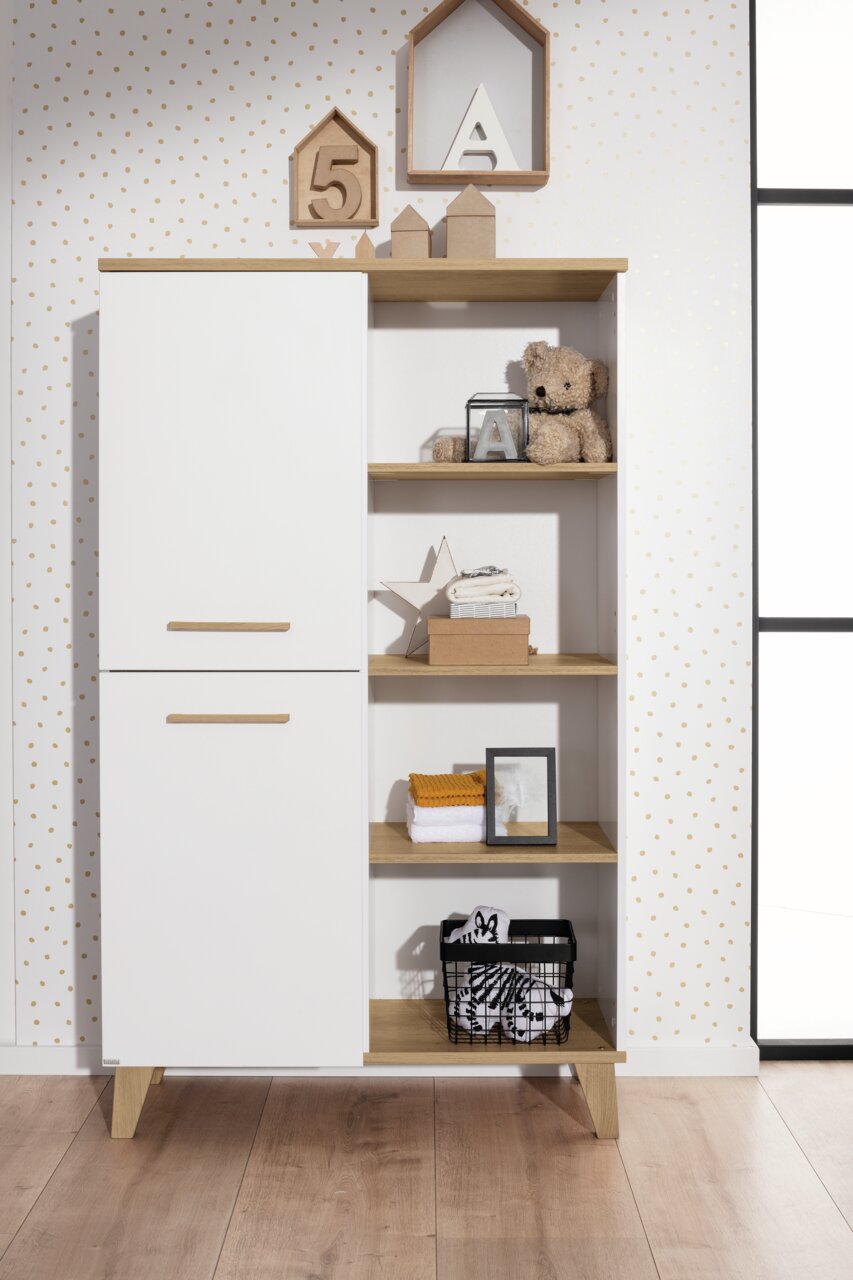 Standregal mit weißer Tür und offenen Regalfächern, gefüllt mit Dekorationen und Spielzeug, aus frontaler Perspektive.