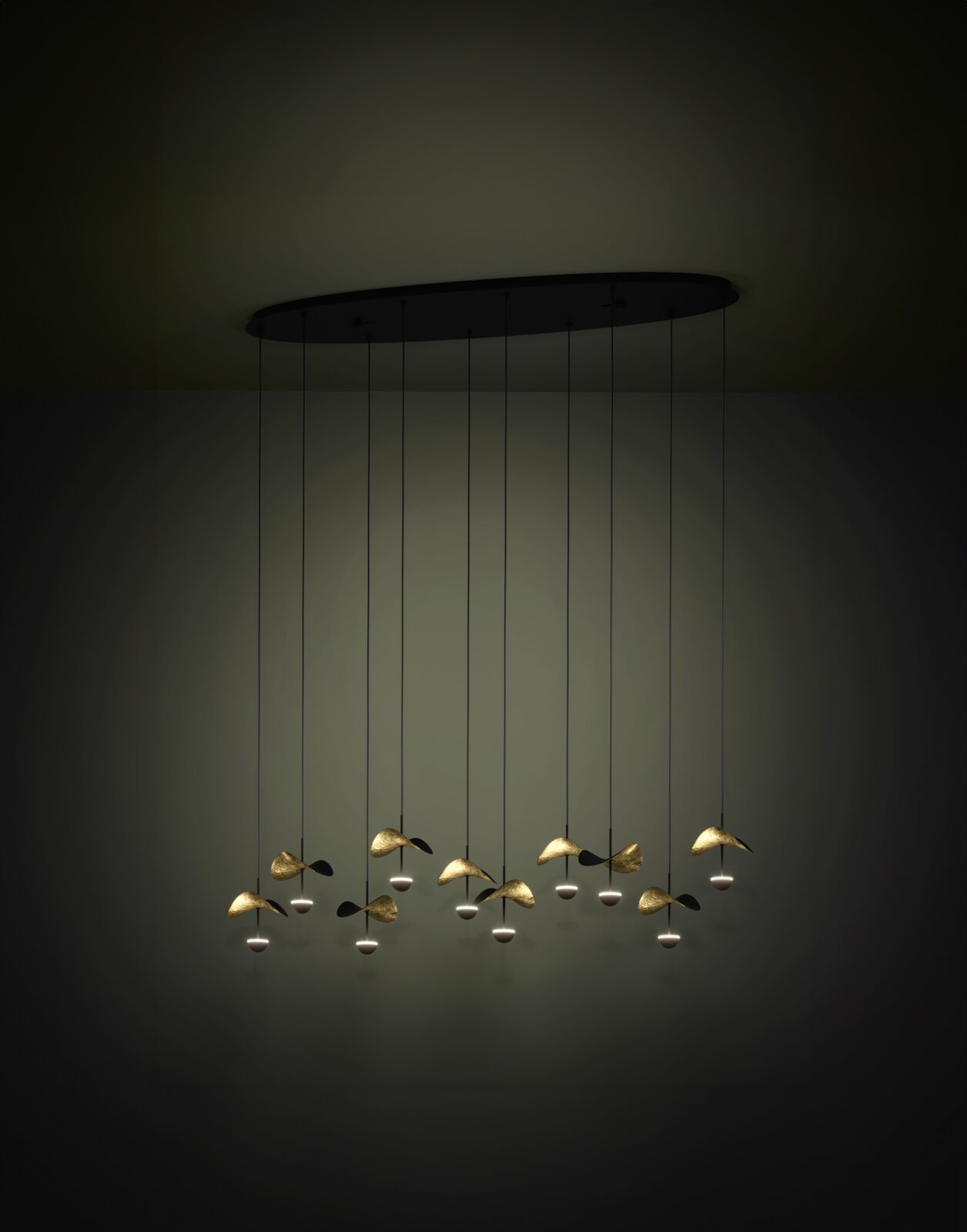 Moderne LED-Pendelleuchte mit ovaler schwarzer Deckenplatte und mehreren goldfarbenen, blattförmigen Lichtmodulen an langen Kabeln, frontal leicht von unten fotografiert