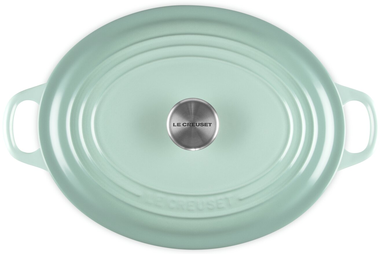 Mintgrüner ovaler Le Creuset Bräter mit Deckel und seitlichen Griffen, Draufsicht von oben auf weißem Hintergrund
